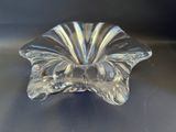 bol en verre transparent en forme de fleur posé sur un socle noir