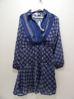 une photo d'une chemise bleue et blanche suspendue à un cintre
