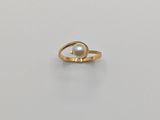 une bague en or avec une perle au centre