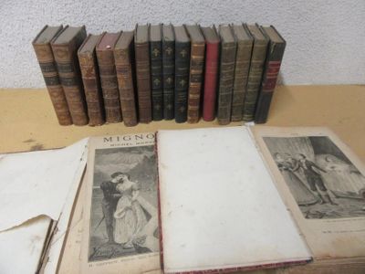 several old books sitting on top of a wooden table next to each other