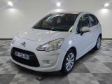 la petite voiture blanche est garée sur un sol en damier