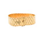 a close up of a gold bracelet on a white background