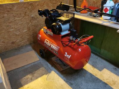 un petit compresseur d'air posé sur le sol d'une pièce