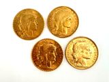 four different types of gold coins on a white surface