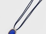 a necklace with a blue stone on a black cord