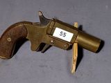 un pistolet avec une crosse en bois posé sur une surface grise
