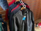 many jackets hanging on a clothes rack in a store