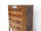 a small chest of drawers in a white room