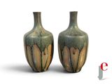 two vases sitting next to each other on a white surface