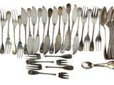 many forks and spoons arranged together on a table