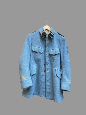 une photo d'une veste militaire bleue suspendue à un cintre