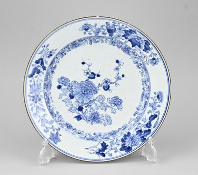 une assiette bleue et blanche ornée d'un motif floral