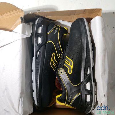 deux paires de chaussures dans une boîte posée par terre