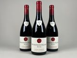 trois bouteilles de vin rouge sont alignées sur une table