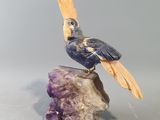 une figurine représentant un oiseau perché sur un rocher