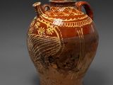 un vase marron orné d'un oiseau sur un fond gris
