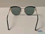 the sunglasses are black and gold with green lenses on them