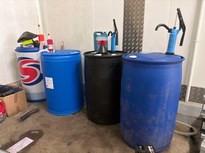 deux fûts bleus et deux fûts noirs dans un garage