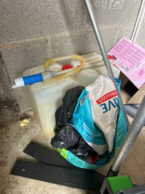 a bag of garbage on the floor next to a mop and a bucket