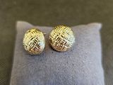 un gros plan sur une paire de boucles d'oreilles posées sur un oreiller