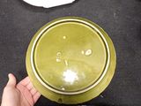 a person holding a green bowl on a table