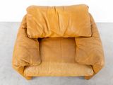 a brown leather chair with a pillow on top of it