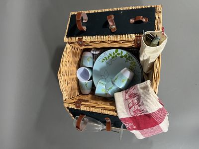 un panier en osier contenant des assiettes et des tasses