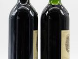 two bottles of wine sitting next to each other on a white surface