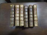Quatre vieux livres sont alignés sur une table en bois