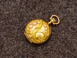 une image représentant une montre de poche de couleur dorée, sertie de diamants