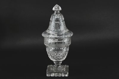 a close up of a glass vase with a lid on a black background