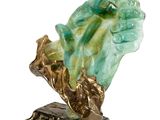 statue of a hand holding a leaf on a base