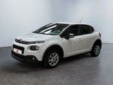Une Citroën blanche est garée dans une pièce blanche