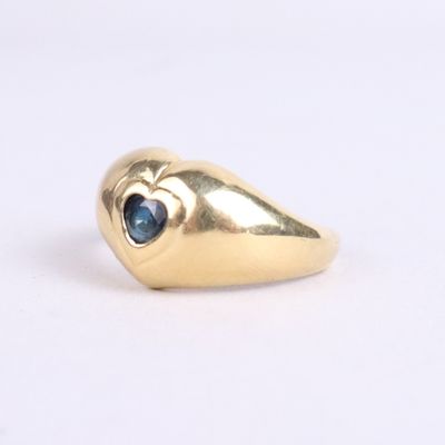 an image of a gold ring with a blue stone in the middle