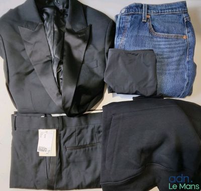 un costume, une cravate et un jean posés sur une table