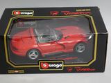 une petite voiture rouge dans une boîte posée sur une table