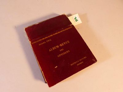 un livre rouge posé sur une table, sur lequel est accrochée une étiquette