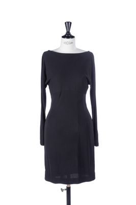 a black dress on a mannequin stand with a white background