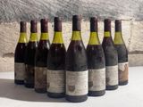 six bottles of wine are lined up in a row on a table