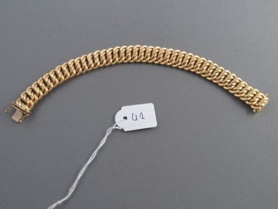 une photo d'un bracelet en or avec une étiquette de prix accrochée dessus