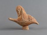 un petit oiseau en argile posé sur une table