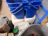 a blue bucket sitting on top of a toilet next to a blue bucket