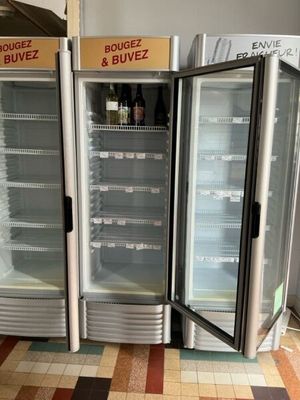 three refrigerators that are sitting in the middle of the floor