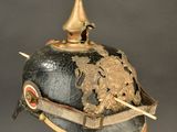 an old helmet with a gold crown on top of a stand
