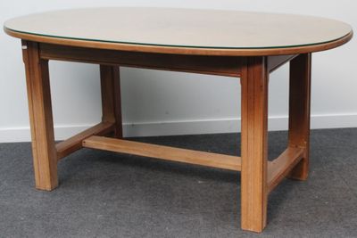 une photo d'une table en bois avec un plateau en verre, posée sur un sol recouvert de moquette