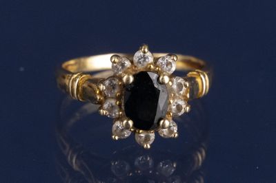 un gros plan d'une bague en or sertie d'une pierre noire entourée de diamants blancs