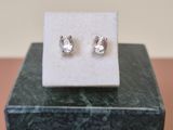 un gros plan sur une paire de boucles d'oreilles posées sur un bloc de marbre