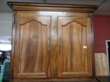 a large wooden armoire in the middle of a room