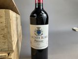a bottle of wine sitting on a table next to a wooden box