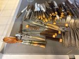 many different types of knives and forks laid out on a table